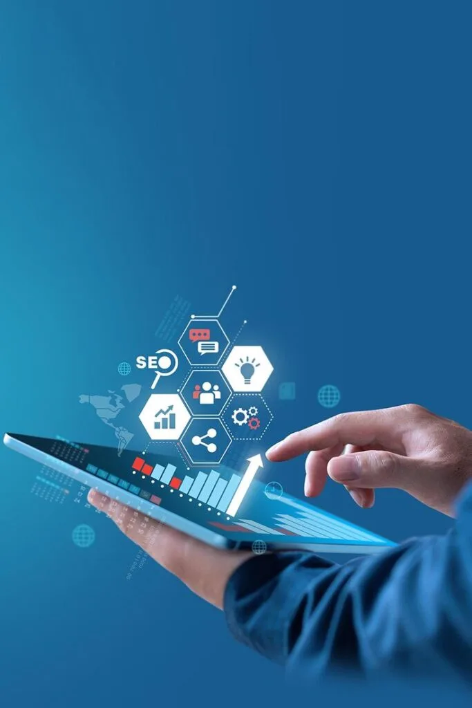 Mano con una tableta que proyecta gráficos y elementos de marketing digital, como SEO y análisis de datos,